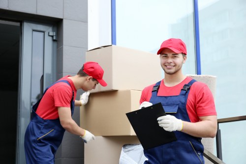 Local removals team loading furniture for transport near a riverside area